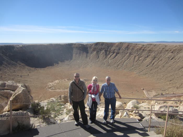My wife with her brother on her right and me on her left posing above the Meteor Crater.