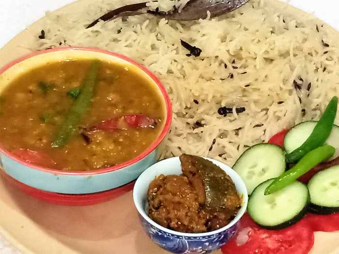 Dal chawal (lentils and rice) served with salad and mango pickle