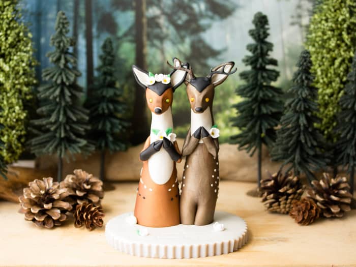 The wedding cake topper that the author commissioned from Bonjour Poupette. The spotted deer symbolize her and her fiance's love for deer and art.