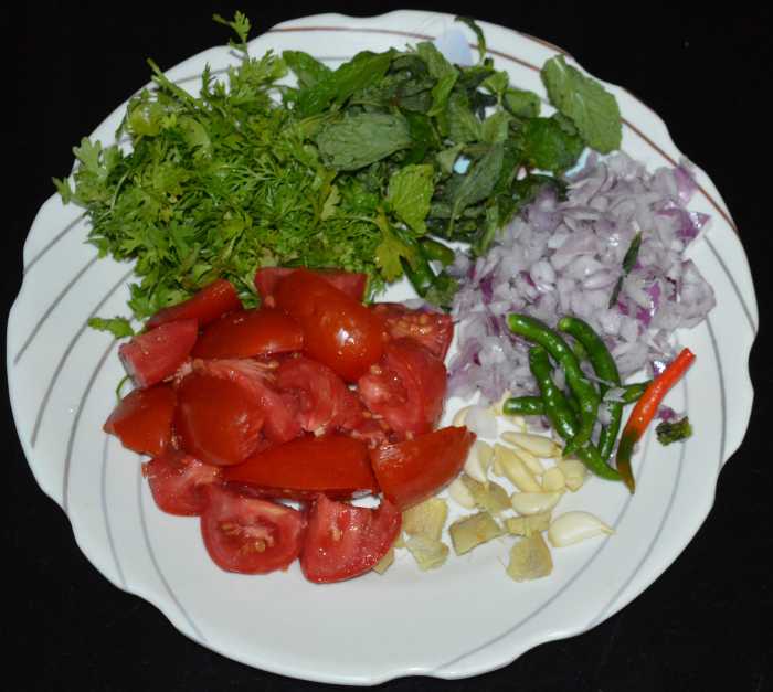 Step two: Heat oil in a deep bottomed pan. Saute the chopped onions, ginger, garlic, coriander leaves and mint leaves as per instructions. Add it to a blender. Add green chilies and tomatoes.
