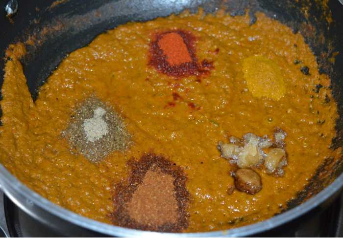 When the paste becomes almost dry, add jaggery, red chili powder, garam masala powder, amchur powder (optional) chaat masala, and turmeric powder. Saute it for a few seconds.