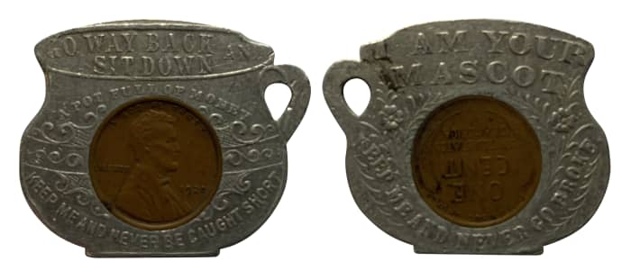 1920 cent encased in an aluminum holder shaped like a chamber pot. The obverse legend reads, “GO WAY BACK AND SIT DOWN/A POT FULL OF MONEY/KEEP ME AND NEVER BE CAUGHT SHORT.” The reverse reads, “I AM YOUR MASCOT/KEEP ME AND NEVER GO BROKE.”