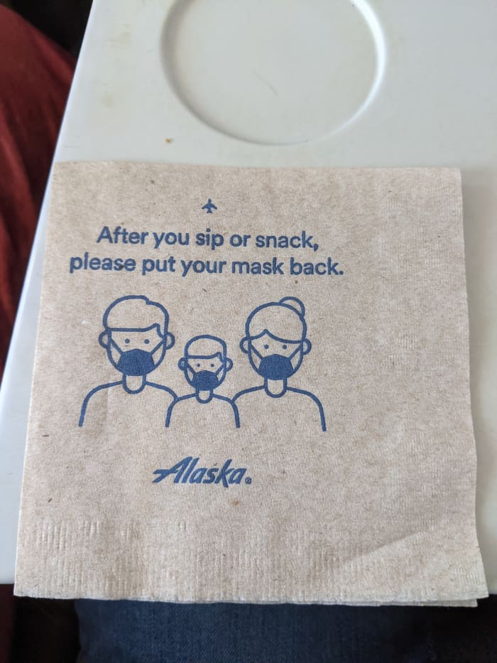 Napkin accompanying snack on Alaska Airlines. Despite CDC advisory individual businesses as well as state and local government regulations can still require everyone, including those vaccinated, to continue to wear masks.