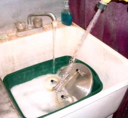 Time to do dishes. The spray-nozzle is rigged straight to the hot water supply, and powers the dishes clean with very little effort. Mr. James often adds a bit of bleach or other sanitizer to the water.