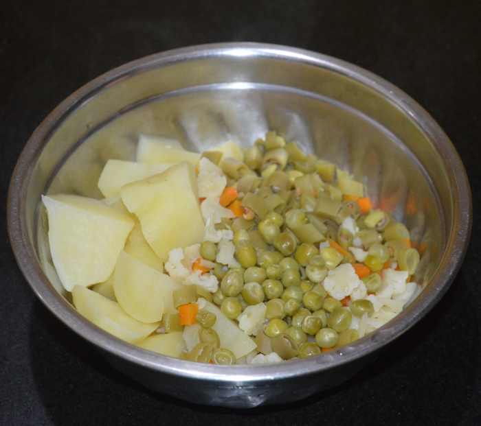 Step three: Take the cooker container out and mash the veggies.