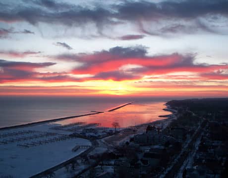 Sunrise over South Shore Yacht Club. Snow rests on the partially frozen harbor. Milwaukee, Wisconsin