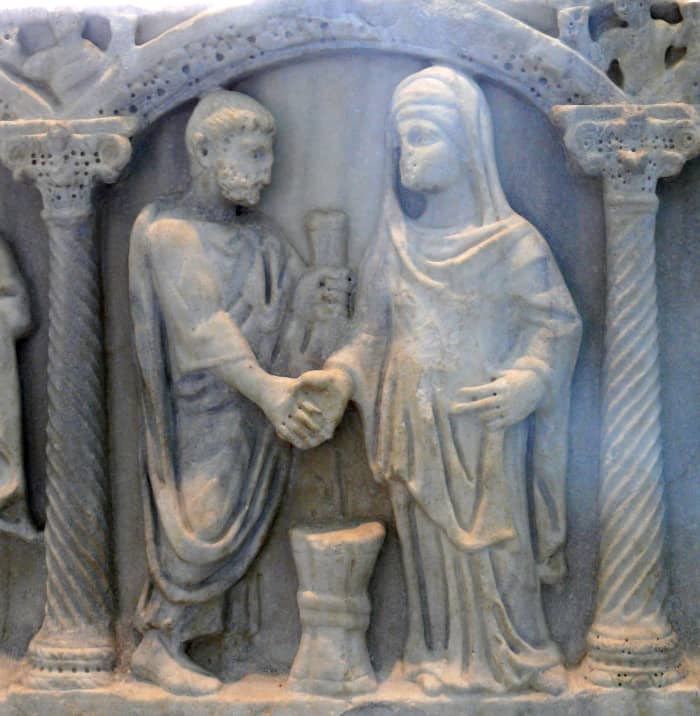 A Roman couple joining hands. The bride's belt tied in a knot symbolized the husband's unification with her.