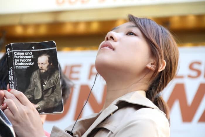 Image of a woman reading Crime & Punishment.