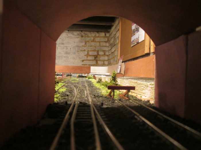 This is now the view out from Unit 1, with the Down road lifted on the lower level Freight, Goods and Mineral line, and replaced under the road bridge with a buffer stop and former trackbed overgrown