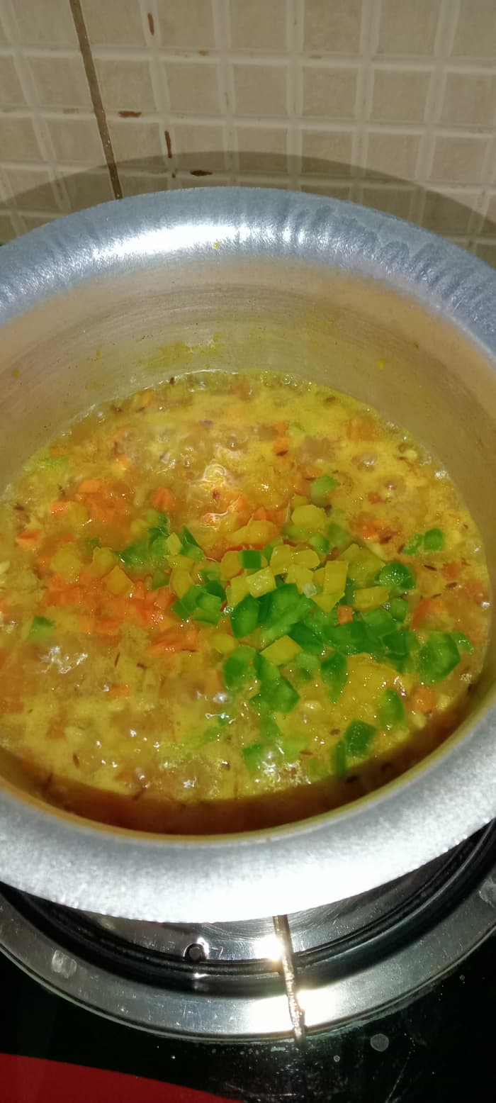 Add some more water as per the quantity of oats. Then add veggies (carrot, bell peppers) and mix well.