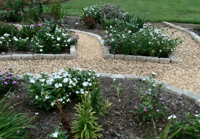 Here's the same photo in the daylight. Notice the pink and purple flowers. There are also some bare spots where tulips have died down. Other summer annuals will fill in those spaces with a little help from me.