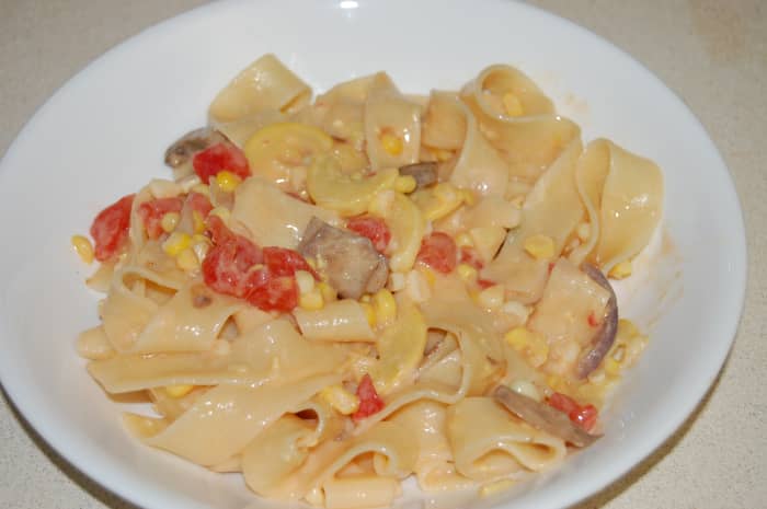 Pappardelle pasta in Alfredo, with mushrooms, fresh yellow squash, fresh tomato, and fresh corn