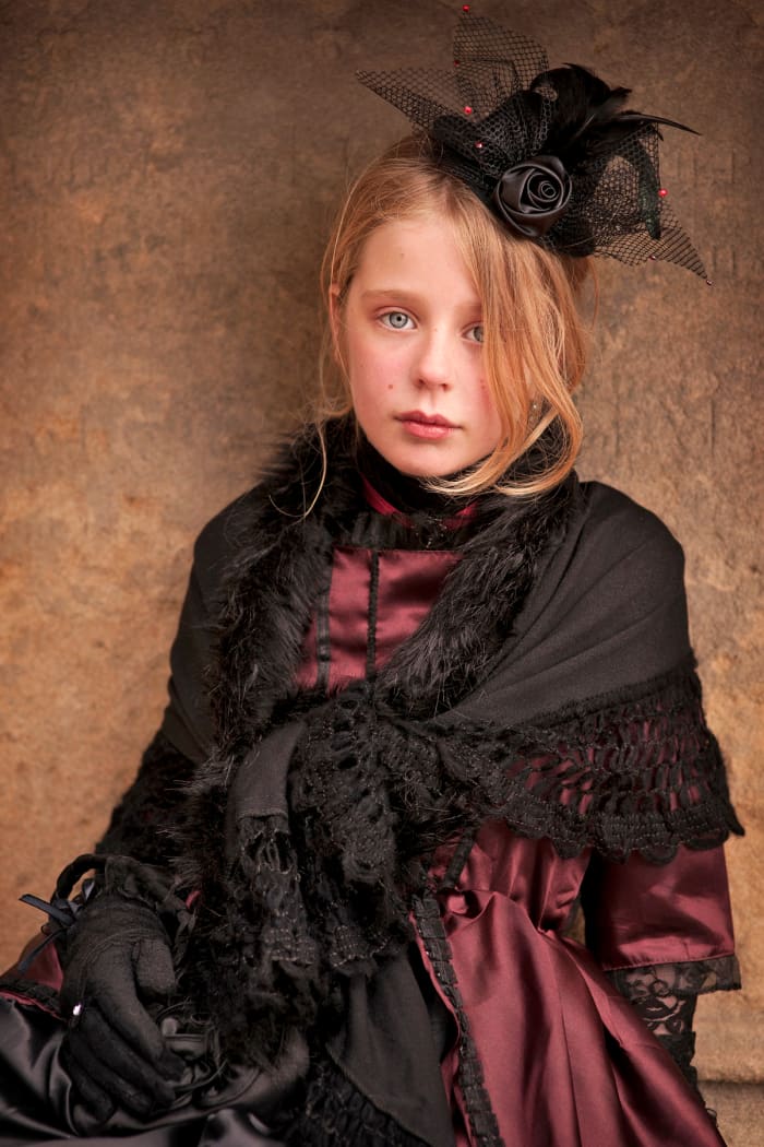 Portrait photograph of a young girl wearing Victorian-style clothing during an appearance at the Whitby Gothic Weekend festival.