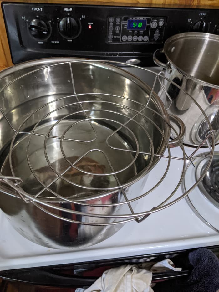 the jar lifter comes out. It holds the jars in place and the handles are above the hot water so you can pull the jars out.