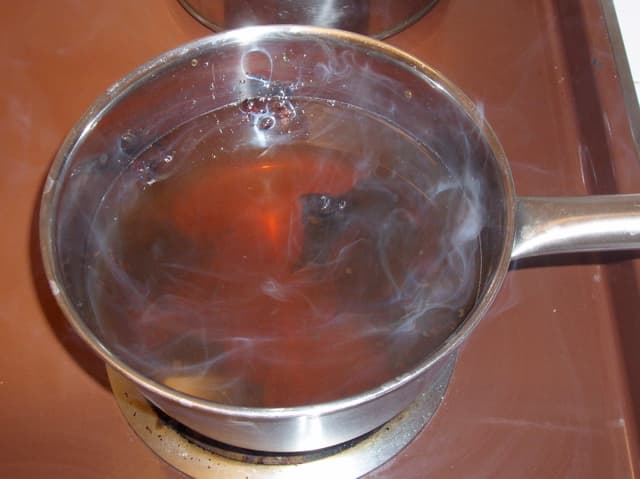A pot of boiling water containing herbs - in this case rose hips, mint, and eucalyptus oil - makes a great DIY facial sauna. This is what I used to do, but it's kind of a hassle.