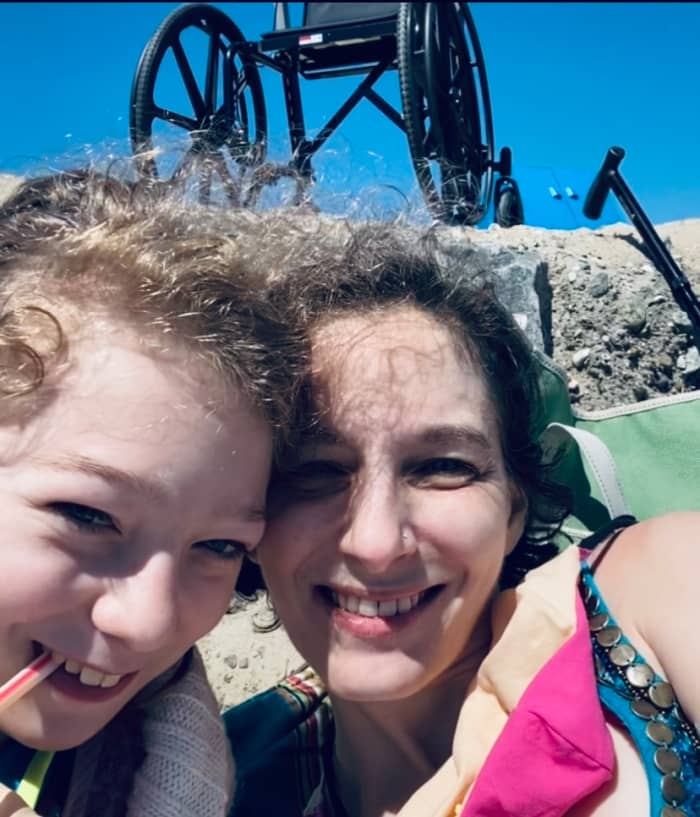 A trip to the beach is made possible with the use of two assistive devices - note the chair and the cane in the background.