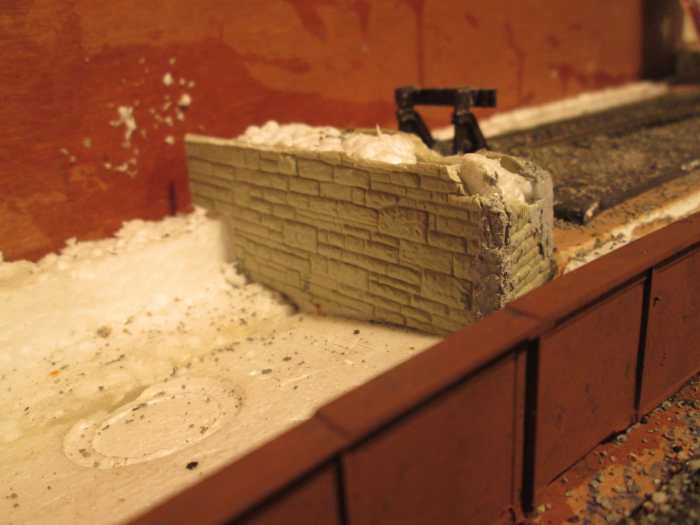 A ruined low foundation wall has been added at the end of the siding, to be given the 'scenic treatment'