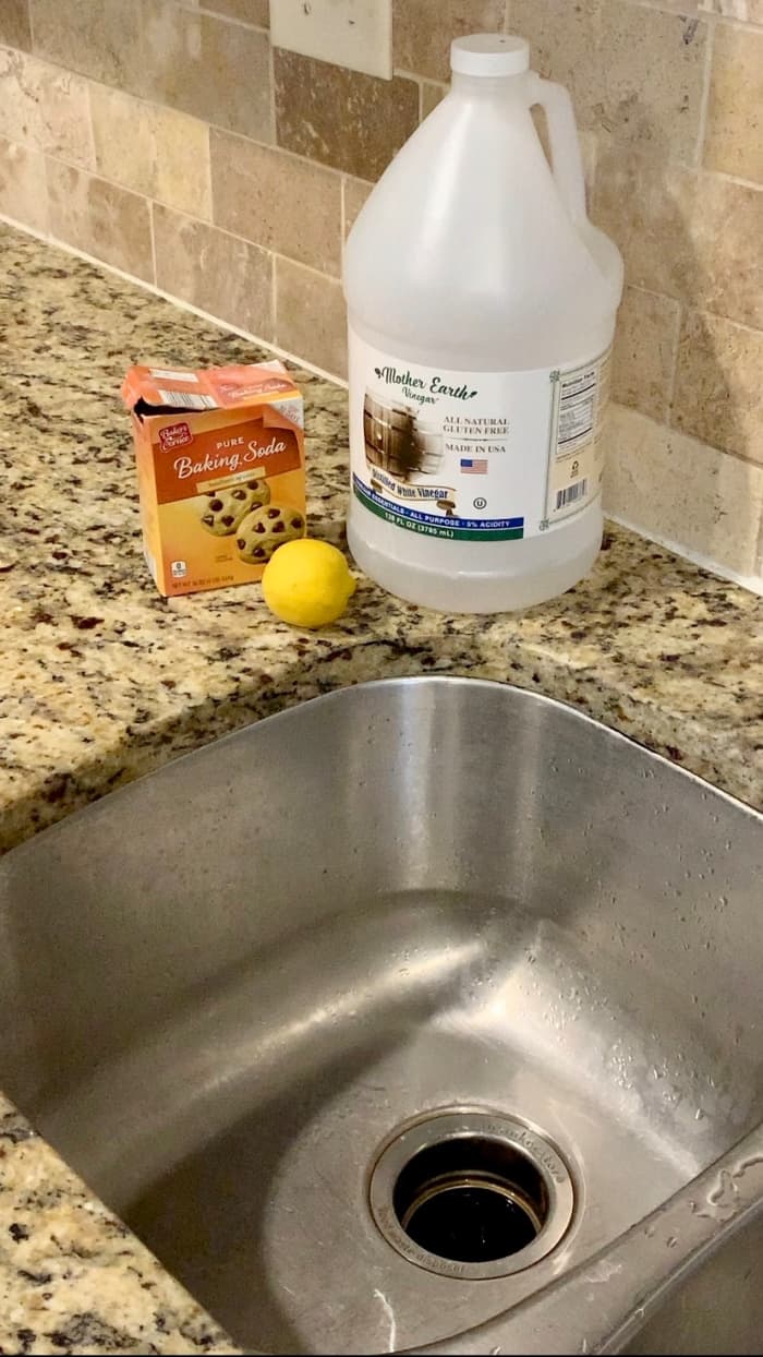 All you need to clean your sink disposal is baking soda, white distilled vinegar, and a lemon.