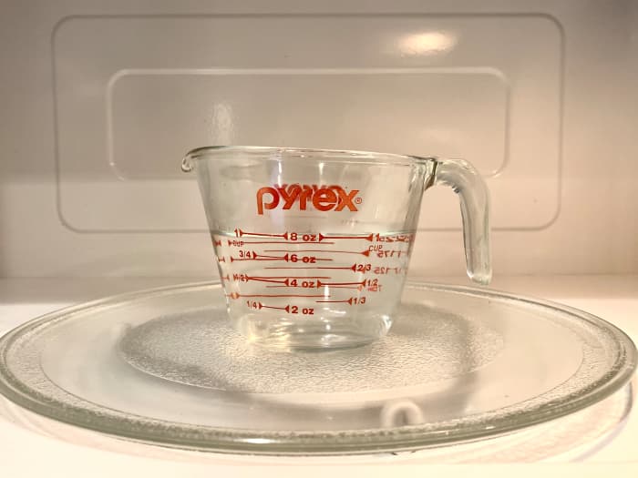Heating up a 50:50 solution of white distilled vinegar and water will loosen dried splatters on the inside of the microwave.