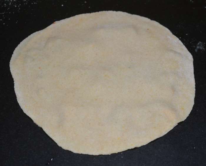 Place another disc on it. Again, spread the tomato sauce and stuffing on the second disc.