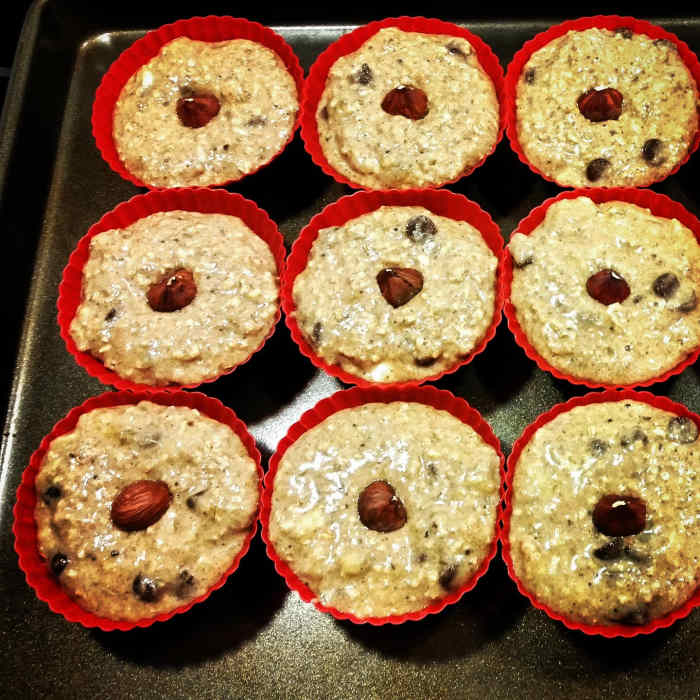 Spoon muffin dough into each silicon baking cup and place a hazelnut on top.