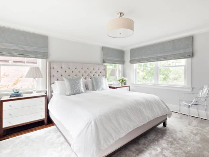 A luxe, silver rug adds softness to the space and coordinates with the metallic pillows and custom Roman shades.