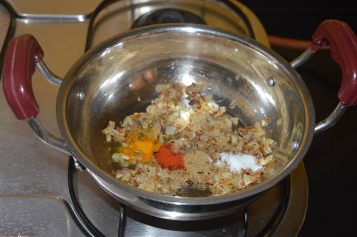 Step two: Add turmeric powder, red chili powder, coriander powder, and salt. Combine with the ingredients in the pan.