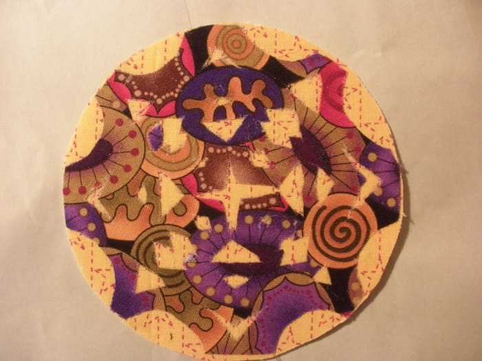 This coaster is made with Fast2Fuse. The appliqué was cut out free form from folded fabric, like a paper snowflake, and attached using Steam-a-Seam2.