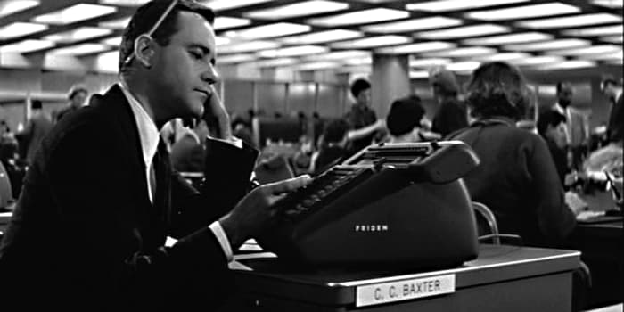 At his desk, C.C Baxter seems to spend as much time arranging appointments for his apartment as he does with work activities