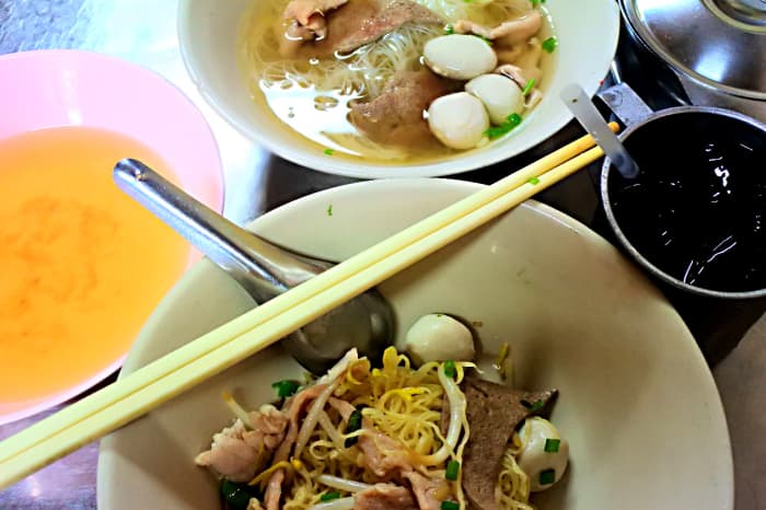 Typical array of dishes and sauces. Chopsticks are not Thai utensils, but are often used for Chinese noodle meals. More typically spoons and forks are used