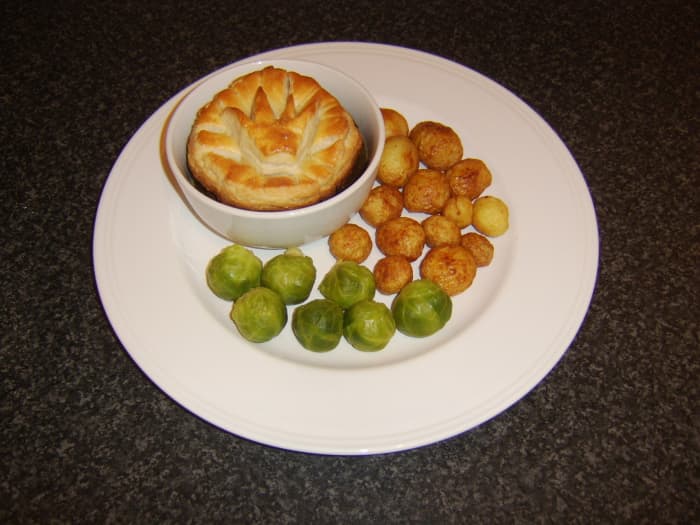 Slowly braised Scottish venison topped with puff pastry and served with roast potatoes and Brussels sprouts