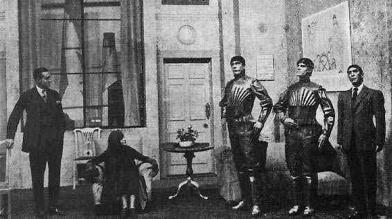 A scene from R.U.R., showing three robots. The play by Karel Čapek is credited with introducing the word "robot" to the general public in 1920. Source: Wikipedia.