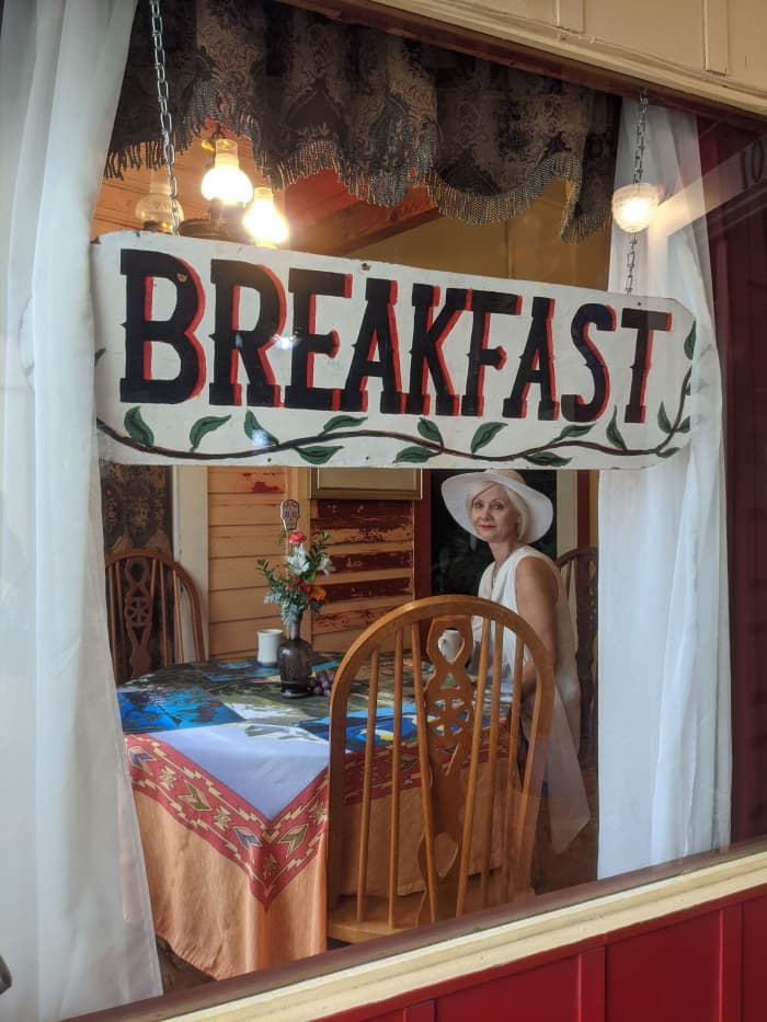 Looking through window in hallway at my wife in at one of the 2 tables in the breakfast room