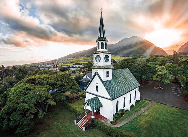 Drones can capture beautiful aerial views like this one of a church with a backdrop mountain view.