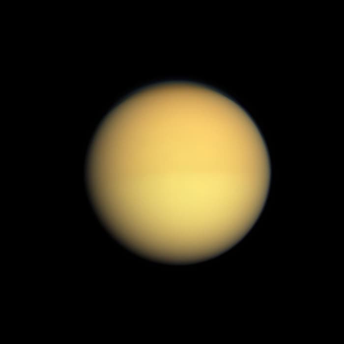 The strange moon Titan. The photo isn't blurred - the fuzziness is caused by the thick atmosphere which shrouds the surface of Titan and which is impenetrable to any attempts at imaging from space