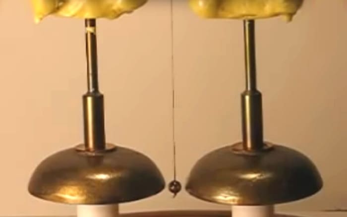 The device made by the instrument manufacturers Watkin and Hill consisted of two brass bells each stationed beneath a dry pile battery, with a metal sphere (or clapper) swinging between them to produce a ring.