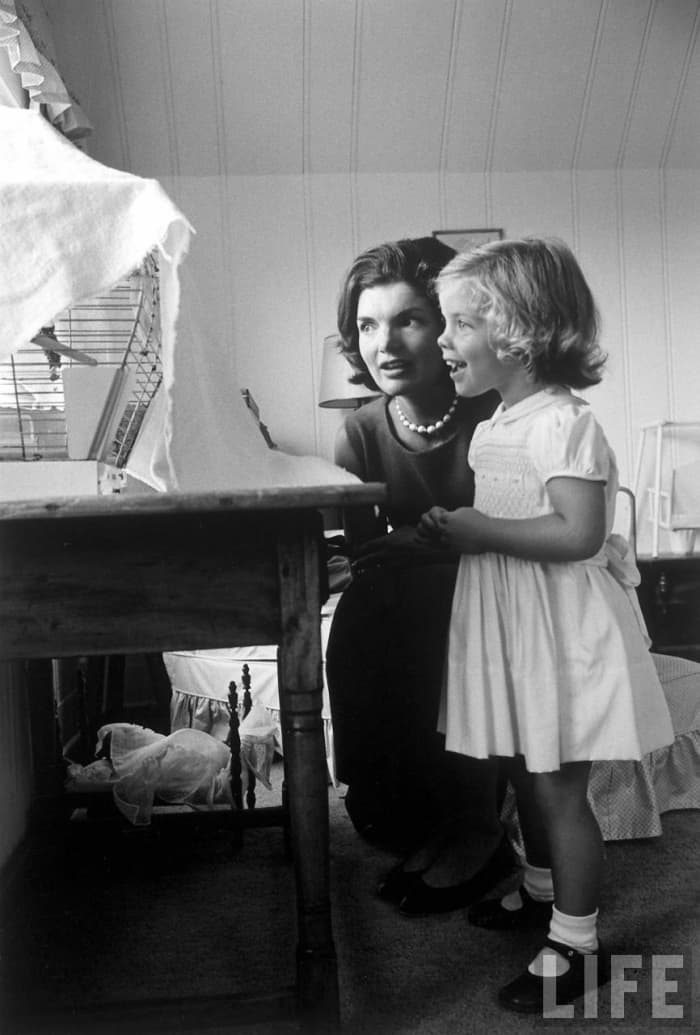 Jackie Kennedy and daughter Caroline by Alfred Eisenstaedt photo watching bird in cage at home