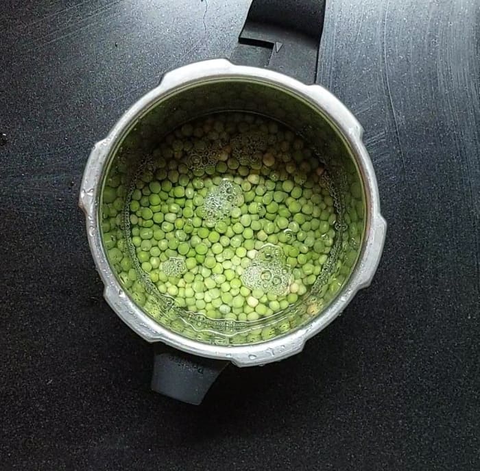After soaking, discard the water and transfer peas to the cooker. Add water to submerge the peas, add salt, close the lid and take 4-5 whistles. Let the pressure subside naturally.