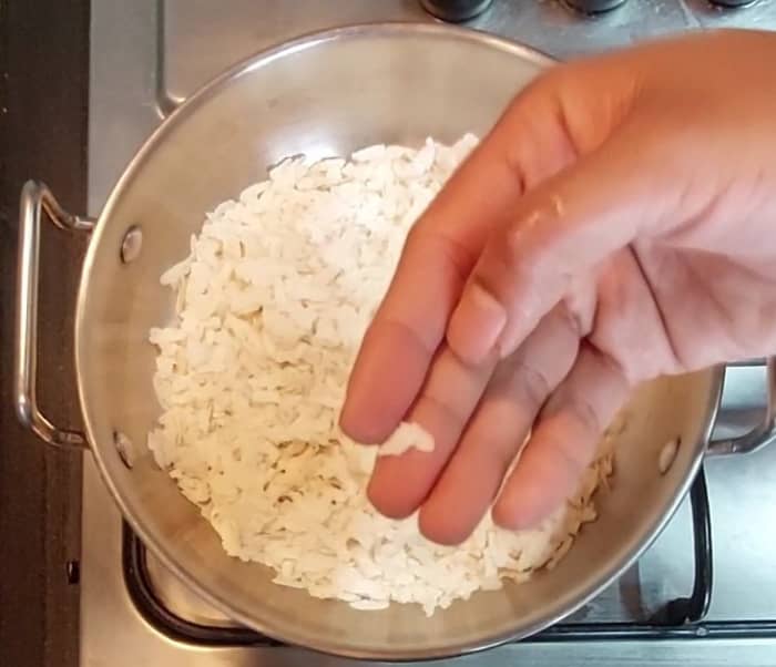 In a pan, add 1 cup thick poha. Fry over medium flame for 3-4 minutes or till poha turns crispy (you can check its crispiness by crushing it between the fingers). Once done, transfer to a plate.