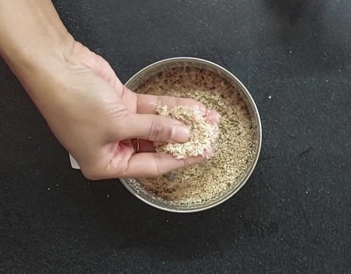 Add fried coconut to the mixer jar, close the lid and grind to a coarse powder. Add it to poha-peanut mixture.