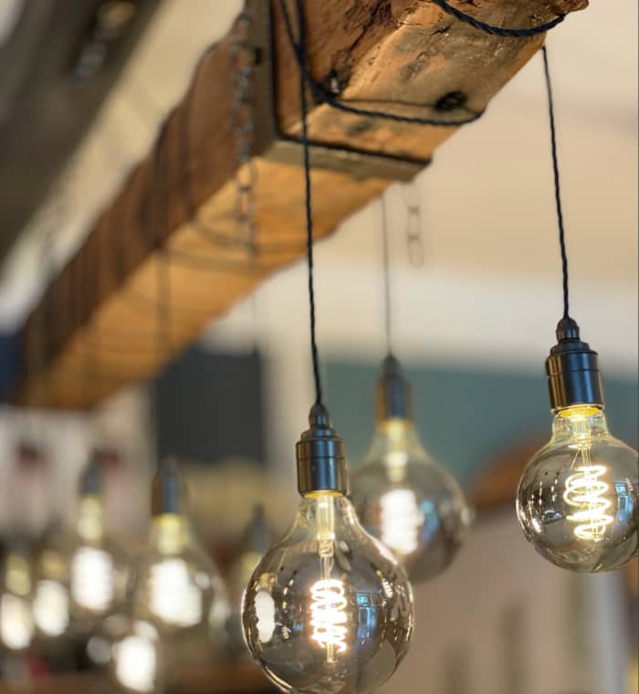 Calex Titanium decorative LED bulbs used here in our oak beam chandelier strike the balance between practicality and ambience.