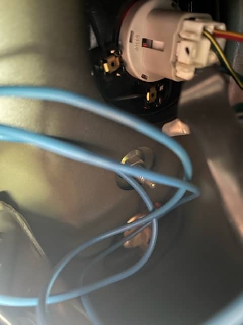 Inside the access area. The brown backup light socket is directly below the large white socket. There is a bolt between the two sockets.