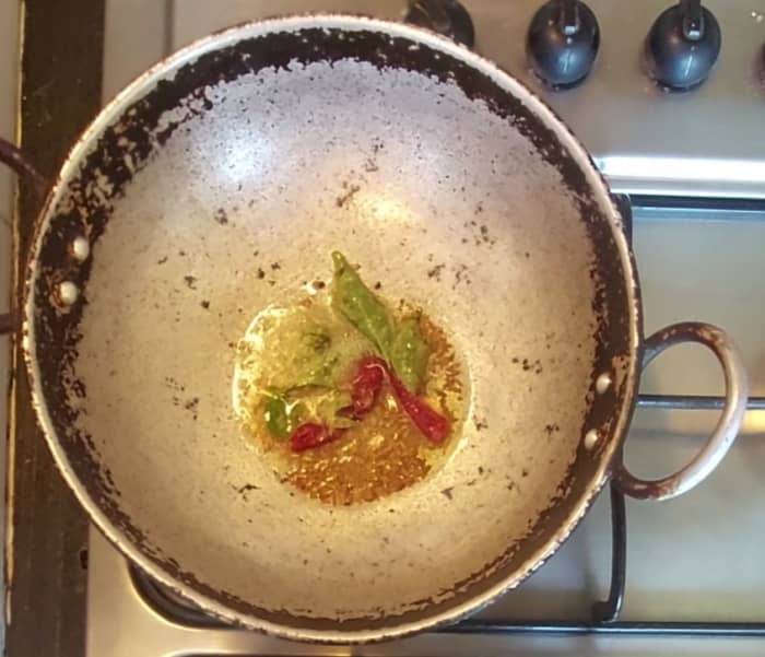 In a pan heat 2 teaspoons oil, splutter 1 teaspoon cumin seeds, add 1-2 broken red chilies, a spring of curry leaves, 1/4 teaspoon hing.