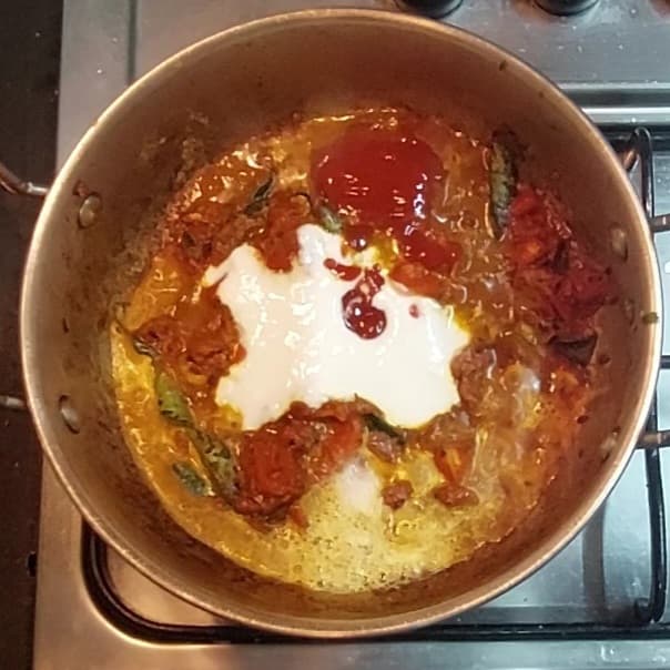 Add 1/2 cup whisked curd, 3 tablespoons fresh cream, 3 tablespoons tomato sauce, mix and combine well.