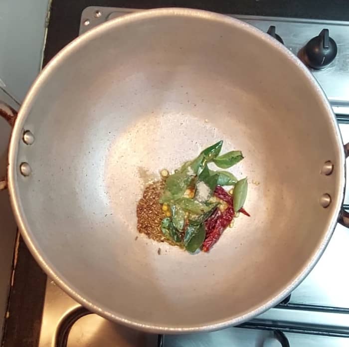 In a pan heat 1 tsp ghee and 1 tsp oil, splutter 1/2 tsp mustard seeds, 1/2 tsp cumin seeds, add 1/2 tsp urad dal, 1/2 tsp chana dal,1-2 broken red chilies, a spring of curry leaves and 1/4 tsp hing. Saute till lentils turns golden brown.