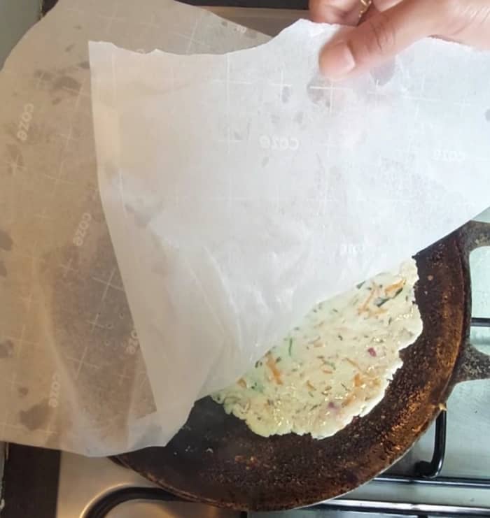 Heat tawa on high flame. Add few drops of ghee, transfer the roti with butter paper on hot tawa, pat for some seconds and remove butter paper carefully.