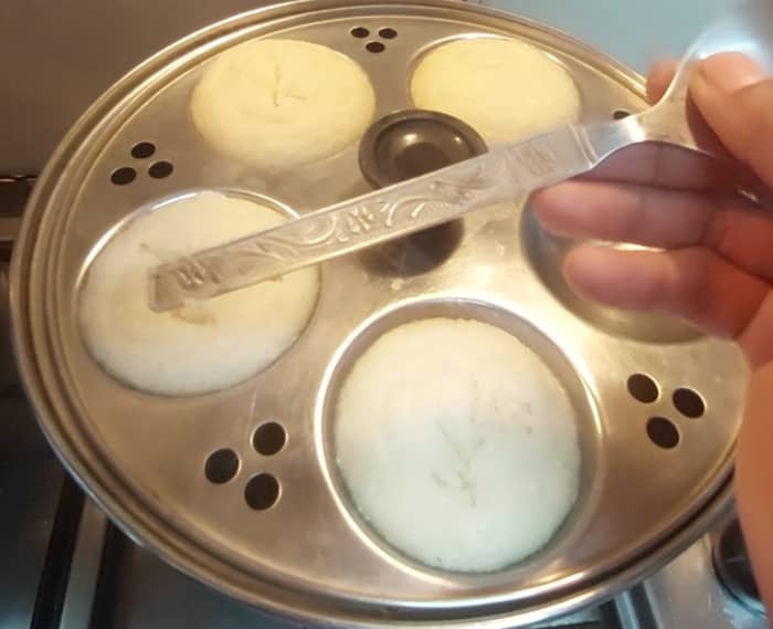 Check the doneness by inserting spoon or fork to the idli. If it came out clean, idlis are cooked well. Switch off the flame and let it set for 5 minutes.