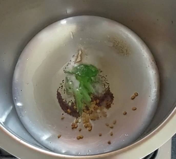 In a pan or vessel, heat 1 teaspoon ghee and 1 teaspoon oil. Splutter 1/2 teaspoon mustard seeds. Add 1/4 teaspoon methi, 1 sprig of curry leaves and 1/4 teaspoon hing. Saute for a few seconds.