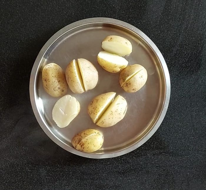 Cook 5-6 potatoes in a cooker for 2-3 whistles or until well cooked. You can cook them in a vessel, too. Let the potatoes cool down.
