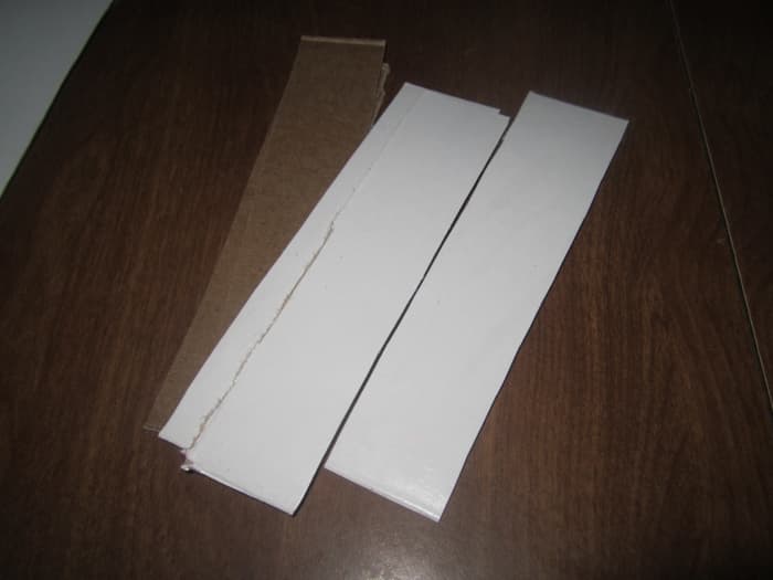 Cut a stack of cardboard (or some other sturdy paper or plastic) slips. Cut some the length of the box and some the width. It may help to sketch out your box and how many compartments you want so you can determine how many slips you'll need.